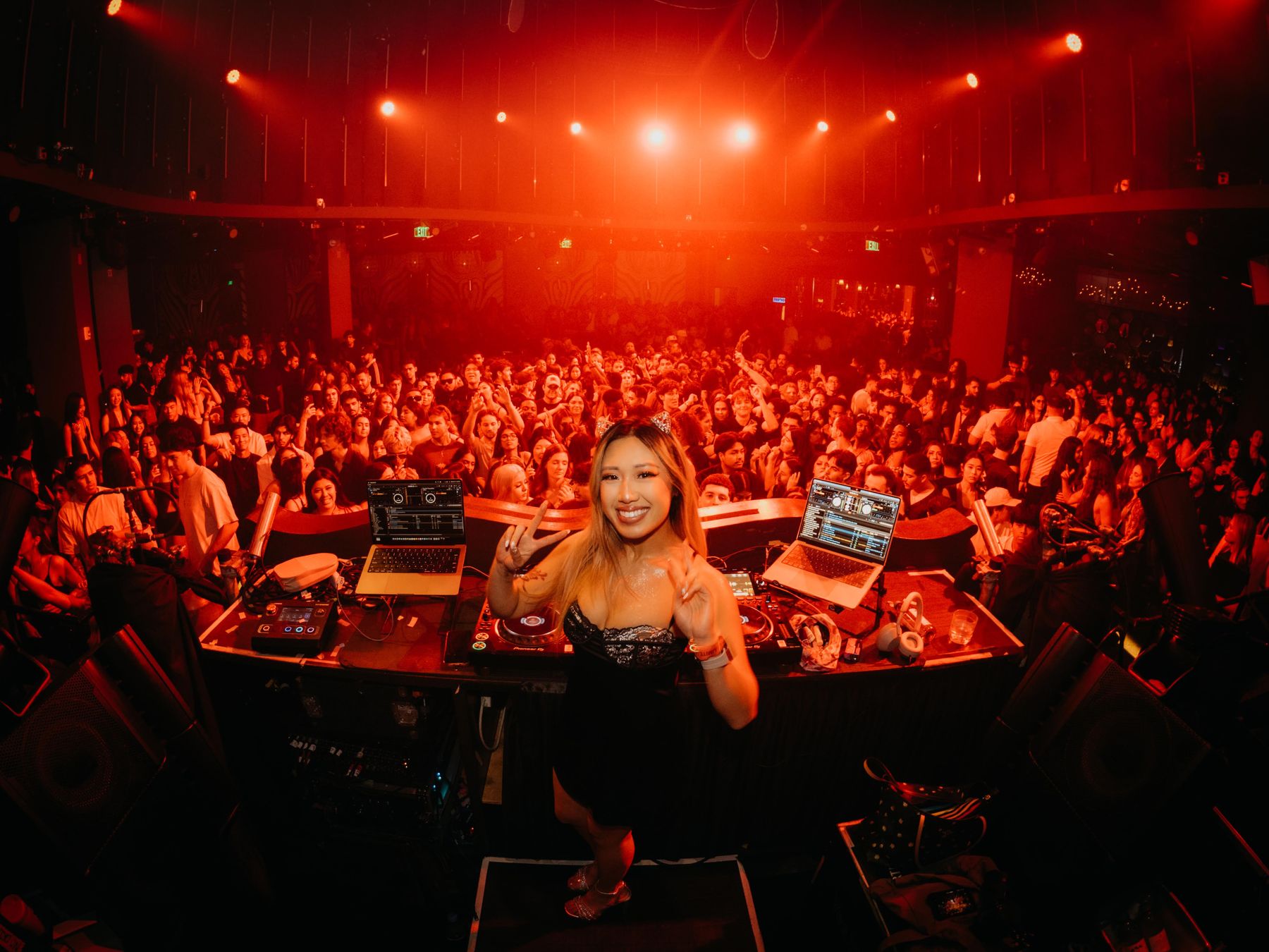 Seduza at the decks in front of a packed room washed in red light